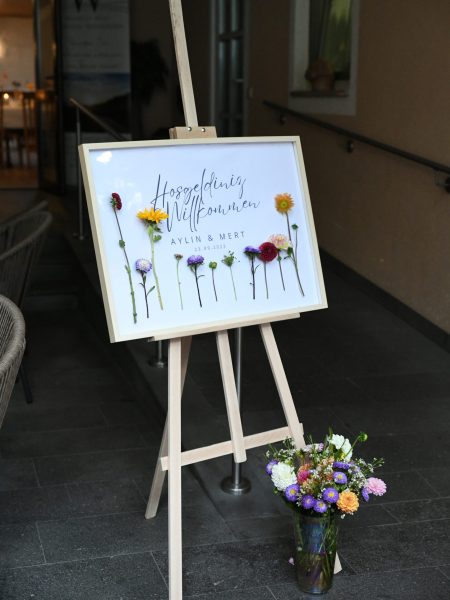 Eingangsschild mit frischen Blumen