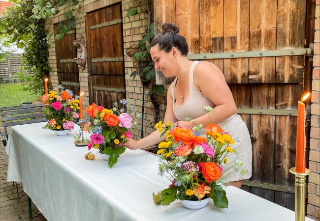 Bunte Blumen und orangene Kerzen